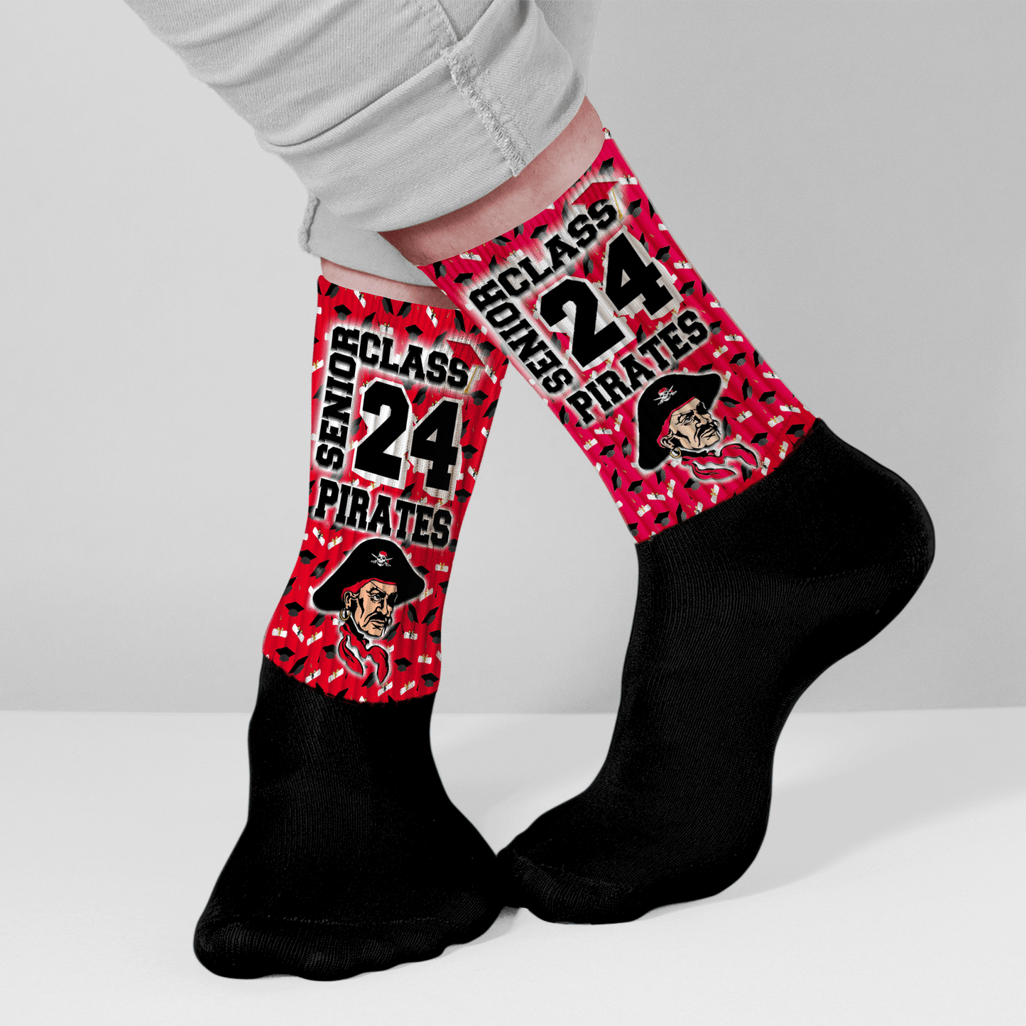 Person wearing red and black socks with custom graduation design for seniors