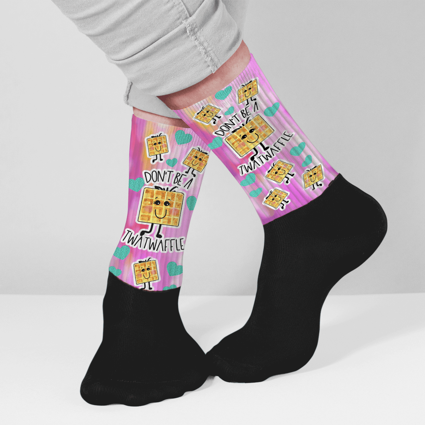 Funny crew socks with “Don’t Be a Twatwaffle” waffle design, pink background, unique nsfw gag gift