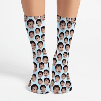 Socks with a pattern of a child's face on a light blue background