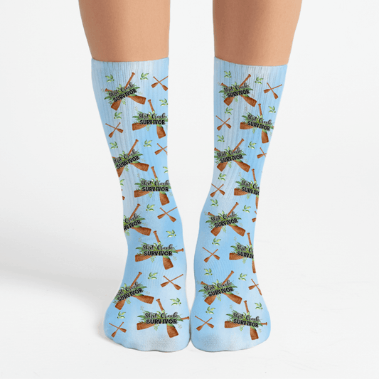 Light blue socks with a funny shit creek survivor design. Great snarky gift idea
