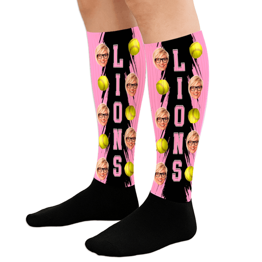Black socks with pink sides featuring tennis ball and face designs, worn by a person.