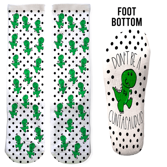 Green cartoon dinosaur crew socks with black polka dots and “Don’t Be a Cuntasaurus” hidden on the foot. Sassy gift for adults.