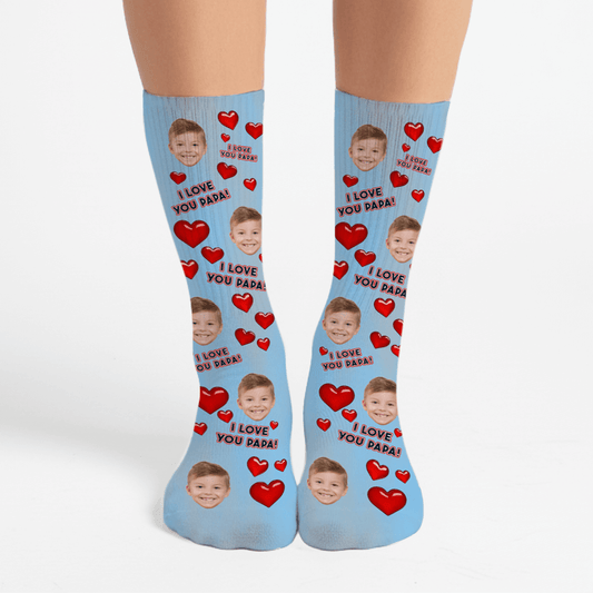 Blue socks with red hearts and a child's face, text 'I Love You Papa' on a white background