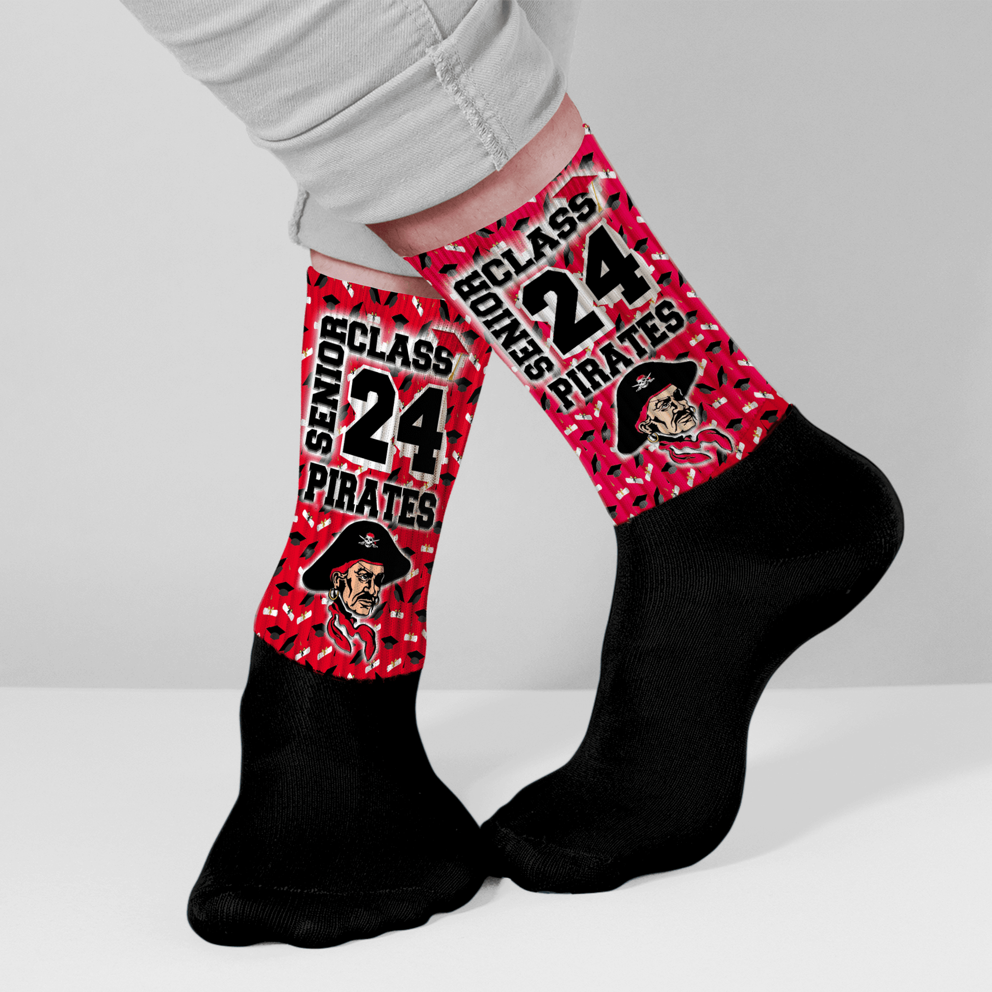 Person wearing red and black socks with custom graduation design for seniors