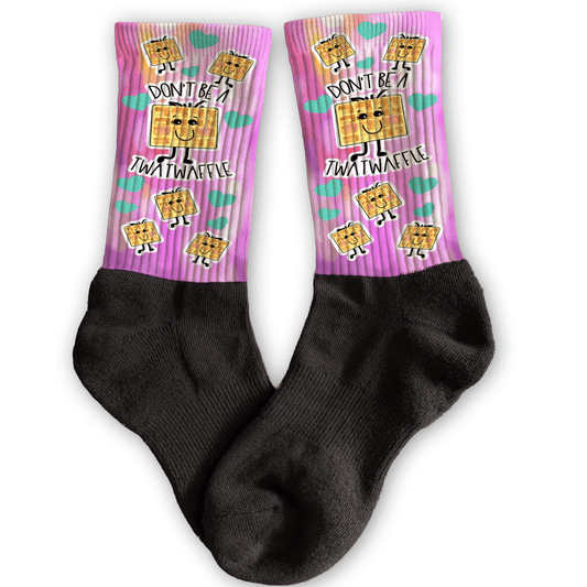 Funny crew socks with “Don’t Be a Twatwaffle” waffle design, pink background, unique rude adult stocking stuffer.